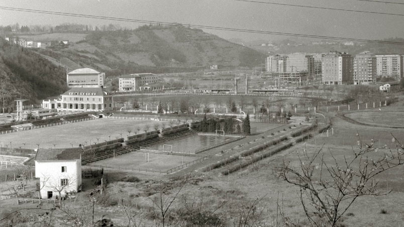 Pelota. Vista de la zona deportiva de Anoeta. Se ve el edificio de las piscinas, el campo de fútbol y atletismo y al fondo el polideportivo