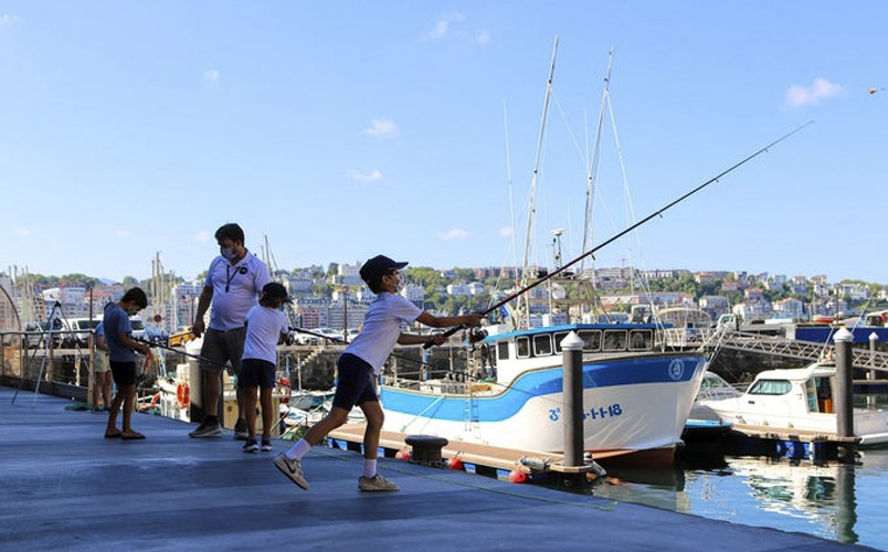 Niño pescando en el puerto de Donostia